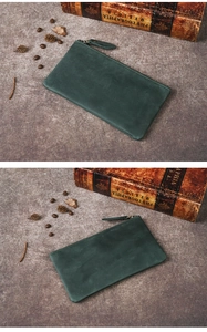 Macro shot of dark green vintage crazy horse leather zipper wallet on rustic background