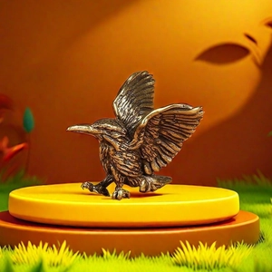 Handcrafted copper hummingbird keychain pendant with detailed wings on a yellow stand
