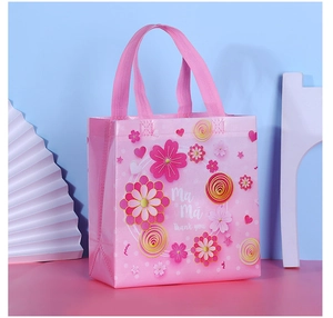 Detailed view of pink non-woven gift bag with floral patterns and Mama Thank You text