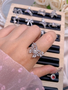 Detailed view of silver butterfly ring with cubic zirconia inlay and white pearl accent