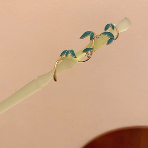 Détail d'une épingle à cheveux chinoise avec feuilles dorées et émail bleu élégant