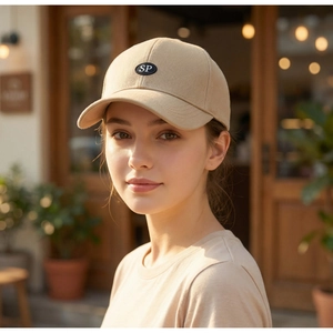 Detailed outdoor shot of a beige cotton baseball cap with SP logo patch on a man