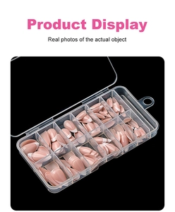 Detail of short almond French tip press-on nails organized in a clear plastic storage box