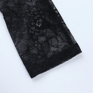 Gros plan sur le motif délicat de dentelle florale noire sur le bord de la manche