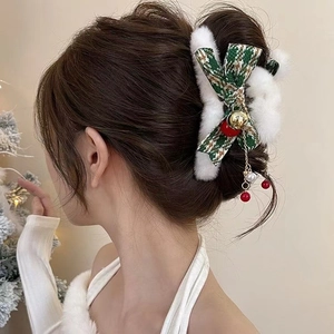 Detail of Christmas plush shark clip with green plaid bow and golden bell tassels