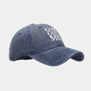 Detail of washed navy cotton baseball cap with white GOD GOT ME embroidered text