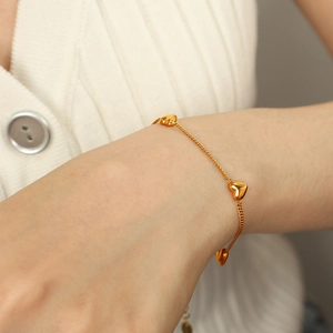 Elegant gold heart charm snake chain bracelet for women on a model's wrist