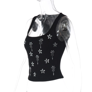 Détail d'un crop top noir en maille côtelée avec strass floraux et décorations de perles