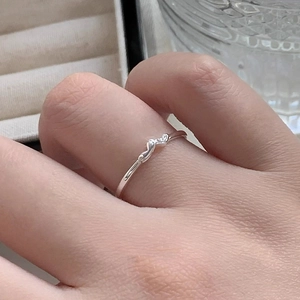 Minimalist s925 silver heart ring on a finger with a delicate polished metal finish