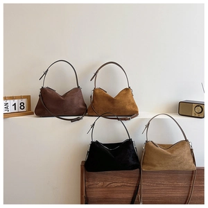 Detail showing four colors of vintage suede shoulder bags with silver metal buckles