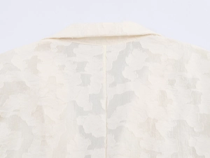 Gros plan détaillé du dos et du col d'un blazer beige avec texture de dentelle florale
