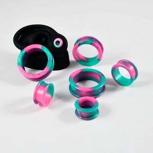 Pink and green marble silicone ear tunnels set with various sizes on ear model