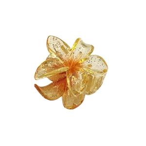 Macro detail of 4cm transparent glitter flower hair claw clip in amber yellow resin
