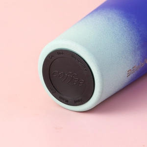 Close-up of insulated coffee mug base with protective silicone pad and washing instructions