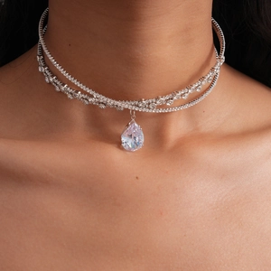 Detail of multi-layer silver choker with zircon teardrop pendant on female neck