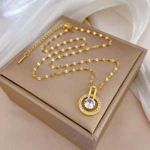 Dettaglio di una collana con pendente a cerchio in zircone dorato su raso e portagioie