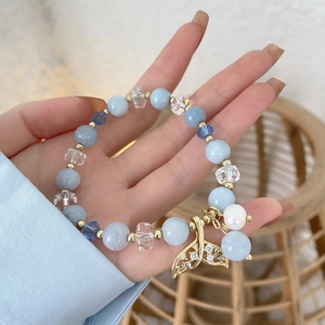 Ocean blue beaded bracelet with a sparkling mermaid tail charm on a delicate gold chain