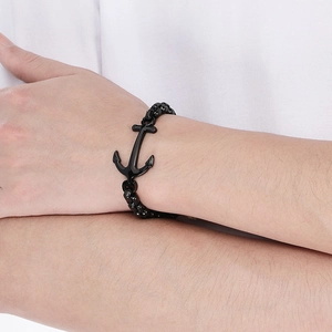 Close-up of a black anchor bracelet for men worn on a wrist with a white shirt