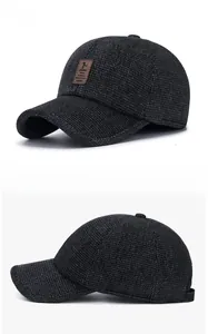 Dettaglio cappello in maglia termica grigio scuro con paraorecchie e toppa in pelle marrone