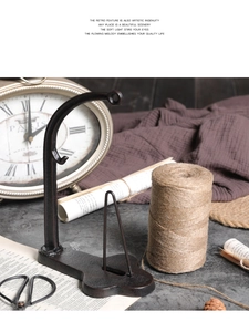 Macro detail of vintage cast iron twine spool holder in a rustic home decor setting