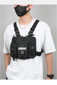Front view of black nylon tactical chest bag with MOLLE webbing on a male model