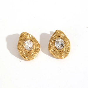 Macro detail of gold irregular water-drop earrings with textured metal and clear crystal