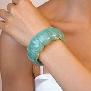 Detailed view of a wide mint green acrylic modular bracelet with marble texture