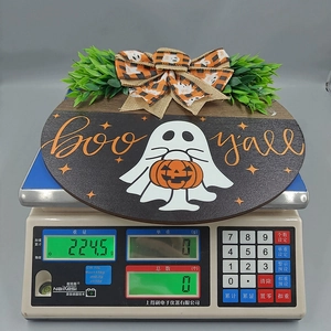 Close-up of wooden Halloween door sign showing weight 224g on a scale for shipping