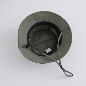 Detail of army green nylon bucket hat showing interior sweatband and adjustable drawstring