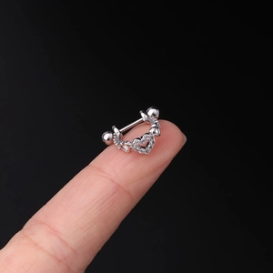 Detail of silver heart cartilage stud with sparkling crystals held on a fingertip