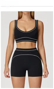 Front view of premium black yoga set featuring white contrast stitching and U-neck bra