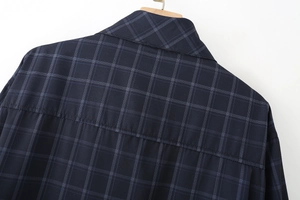 Dettaglio del colletto e del taglio posteriore di una camicia a quadri blu scuro