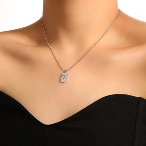 Silver lucky number 7 oval pendant necklace on a snake chain worn by a model