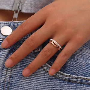 Close-up of rose gold two-in-one ring with Roman numerals and diamond accents