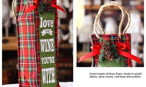 Detail of red and green plaid wine bottle bag with pine cones and festive ribbon