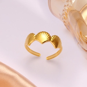 Detailed macro view of triple seashell design ring in gold-plated stainless steel