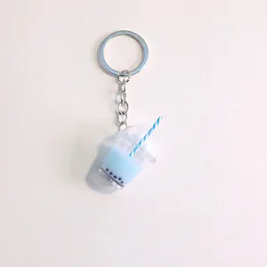 Close-up of a blue bubble tea cup keychain with striped straw and silver metal ring