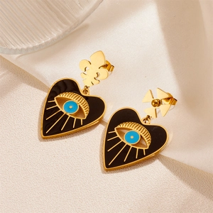 Gold heart-shaped evil eye earrings with fleur-de-lis and cross asymmetric design