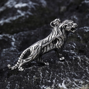 Viking style polished tiger head pendant in silver stainless steel on dark rock background