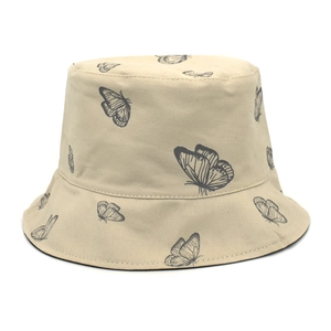 Détail d'un bob beige avec des imprimés papillons minimalistes en tissu de coton sergé