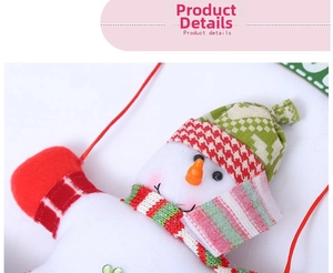 Close-up of plush snowman Christmas ornament with red plaid hat and green heart sequin