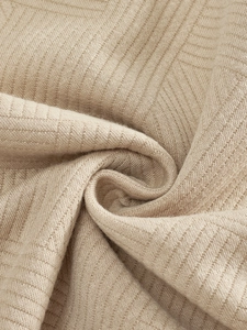 Macro view of beige knit fabric texture with vertical ribbed patterns and soft drape