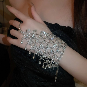 Detail of silver rhinestone slave bracelet with mesh tassel design on female hand
