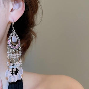 Close-up of pink crystal teardrop tassel earrings with intricate rhinestone embellishments