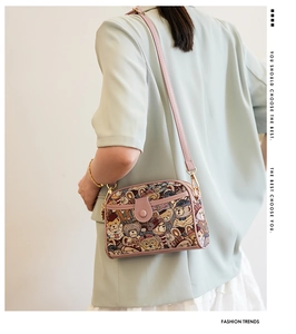 Fashionable pink bear print crossbody bag shown worn by a model in a soft-toned side view