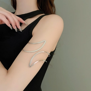 Gros plan d'un bracelet de bras feuille argenté minimaliste porté par un mannequin