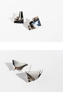 Detailed macro view showing the layered mirror-finish geometric silver earrings texture