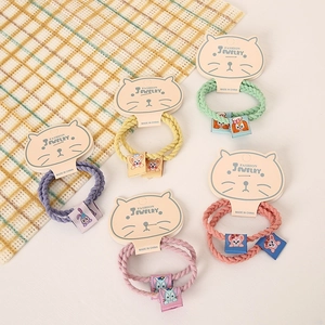 Detail of five colorful twisted rope hair ties with cute cartoon bear and bunny tags