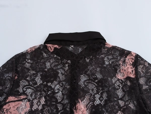Close-up of pink floral lace fabric and black collar detail on women's blouse