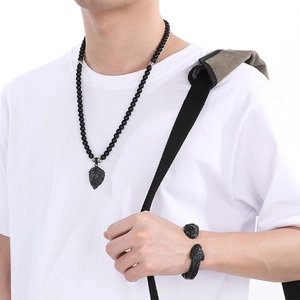 Detail of black onyx beaded necklace with lion head pendant and matching open cuff bracelet
